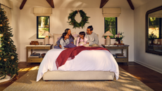 Family sitting on bed with dog